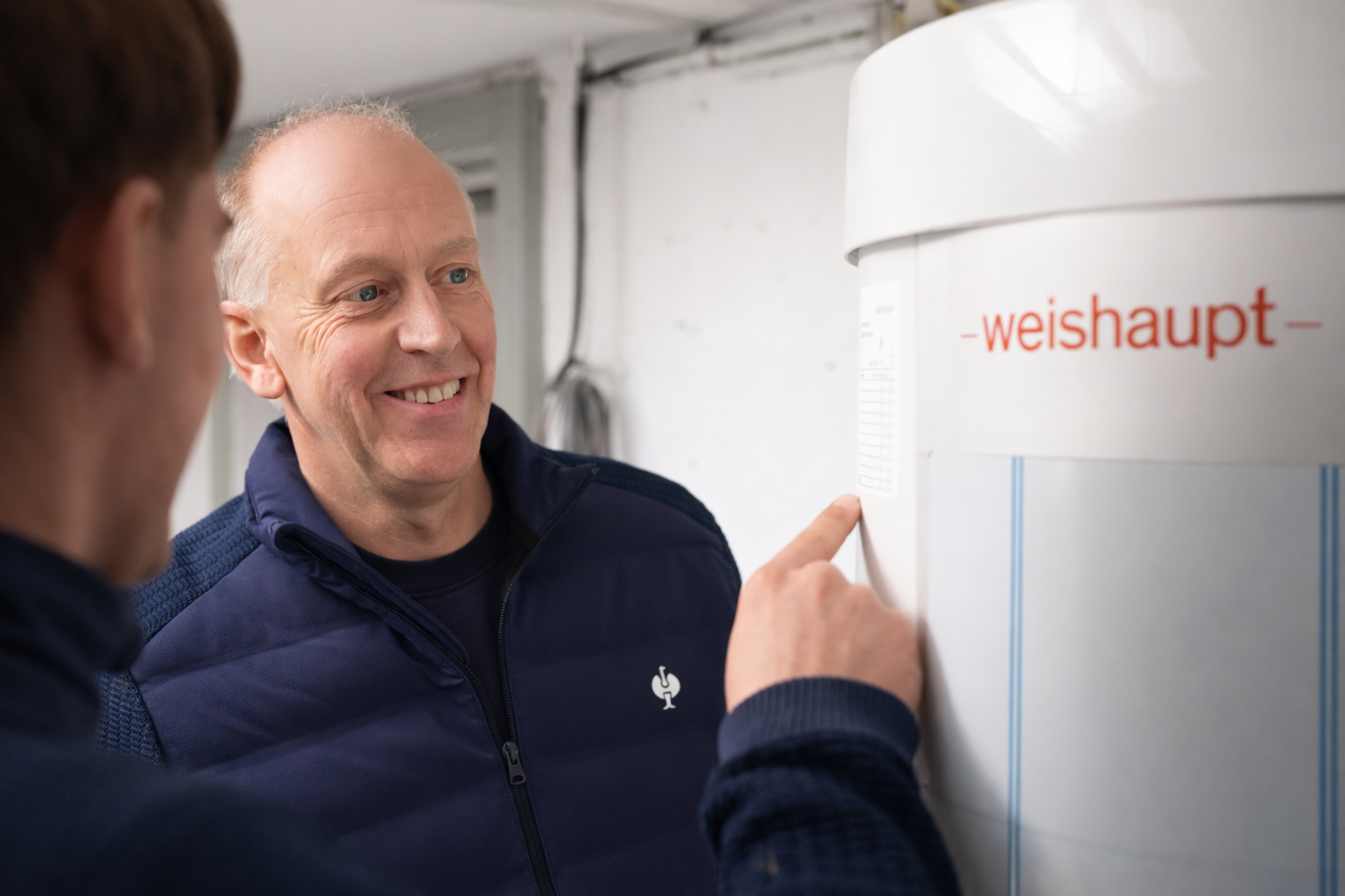 Mitarbeiter von Wolters Haustechnik erklärt eine Weishaupt-Heizungsanlage